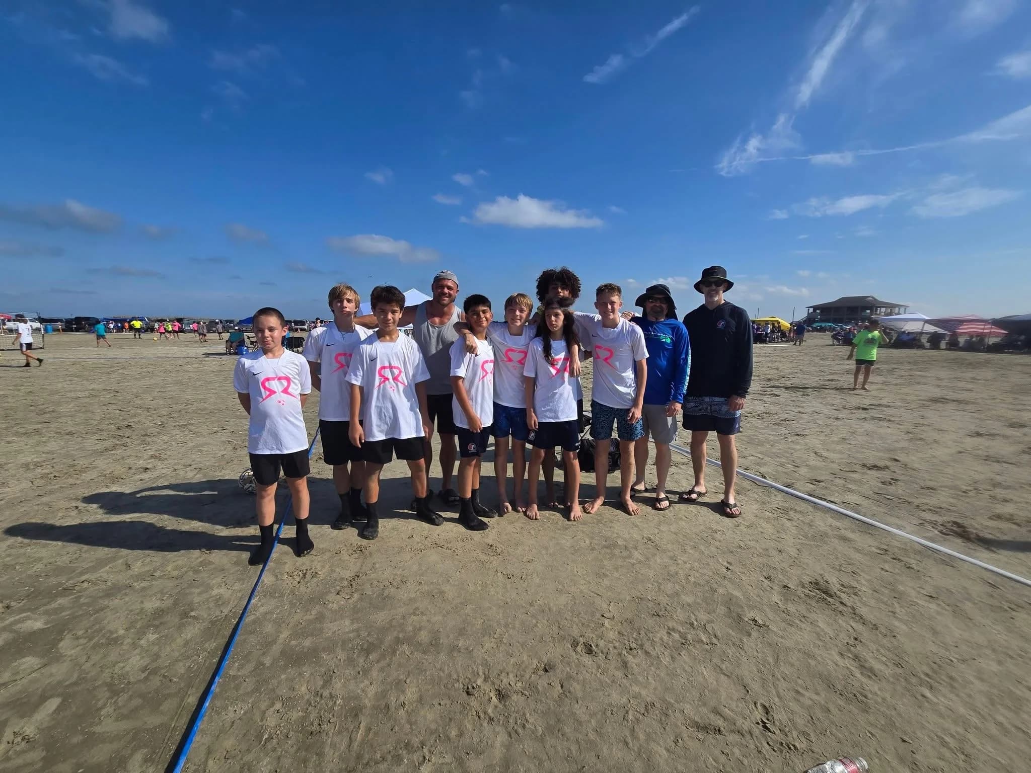 SOLO Soccer players and coaches in white team shirts on the Galveston beach